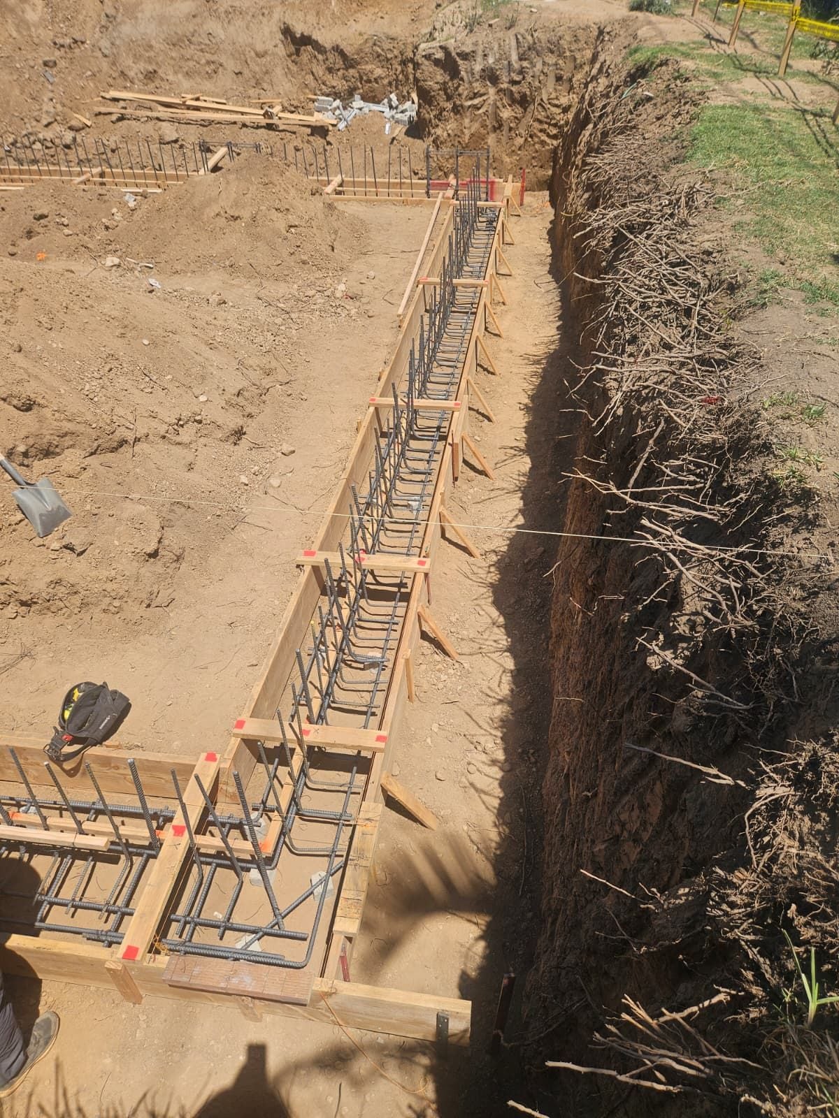 Foundation footing trench with wood forms and tied rebar ready for concrete
