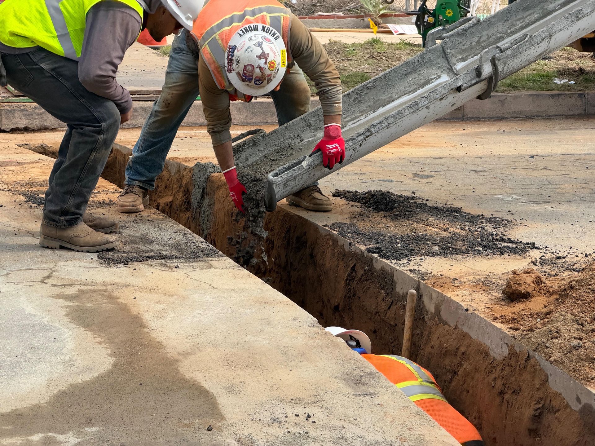 Slurry backfill flowing from the chute into a utility trench